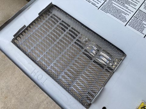 2015 Ford F-550 - Close-up of a water heater burner cover with instructions visible in the background.