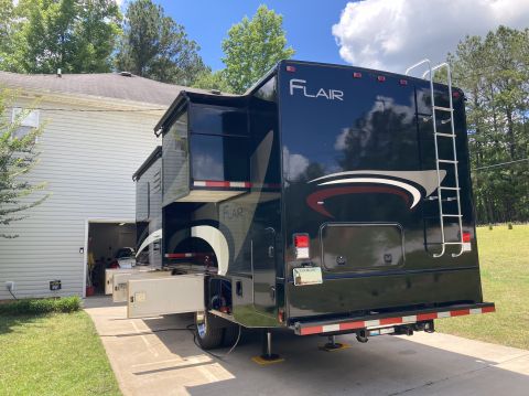 2015 Ford F-550 - RV motorhome with slide-outs extended, parked in a driveway.