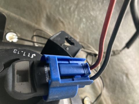 2015 Ford F-550 - Close-up of a blue wiring harness connector attached to a Sylvania bulb, with visible text 'J11.13'.