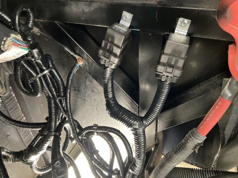 2015 Ford F-550 - Close-up view of a complex wiring harness and two black relays, likely from a vehicle's electrical system.