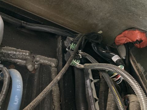 2015 Ford F-550 - Close-up view of a complex engine wiring harness, showing various connectors and protective tubing.