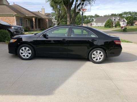 2011 Toyota Camry - Side view of a black 2011 Toyota Camry parked in a suburban driveway.