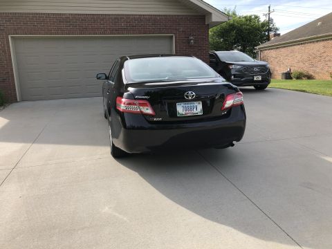 2011 Toyota Camry - Rear view of a black sedan parked in a driveway, with another vehicle visible in the background.