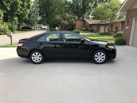 2011 Toyota Camry - Side view of a black sedan, likely a 2007 Toyota Camry, parked on a concrete driveway.