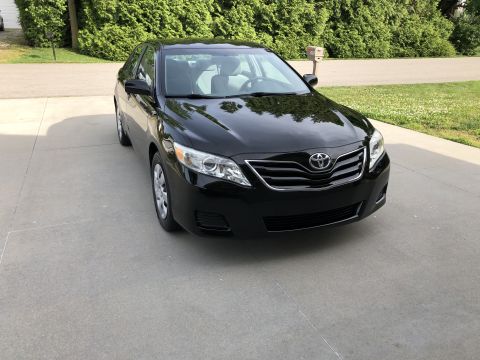 2011 Toyota Camry - A black 2011 Toyota Camry is parked on a concrete driveway.