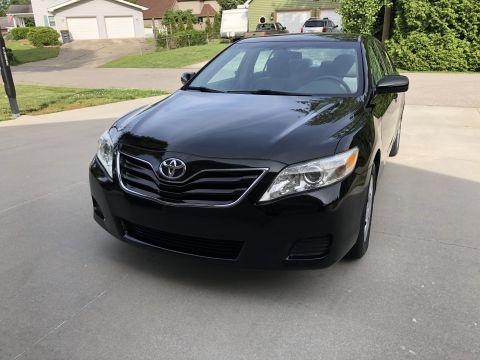 2011 Toyota Camry - A black 2011 Toyota Camry is shown from the front in a residential driveway.