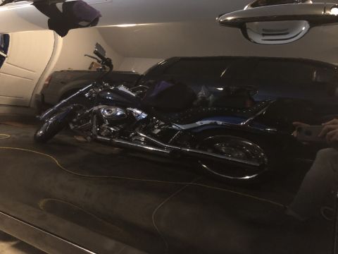 2011 Toyota Camry - Motorcycle parked in front of a dark SUV inside a garage.