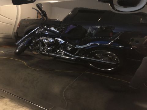 2011 Toyota Camry - A motorcycle is parked in a garage next to a dark SUV.
