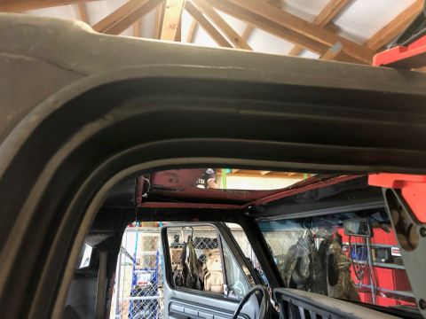 1978 Ford Bronco - The interior of a vehicle is visible, showing a removed roof panel and the underlying structure.