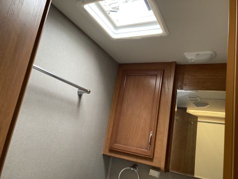 2015 Ford F-550 - Interior view of an RV shows a skylight, wooden cabinetry, and a towel bar mounted on a textured wall.