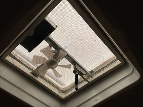 2015 Ford F-550 - Interior view of a roof vent fan with a screen and a manual crank mechanism.