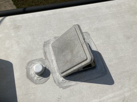 2015 Ford F-550 - Close-up of an RV roof vent fan, with sealant visible around its mounting.
