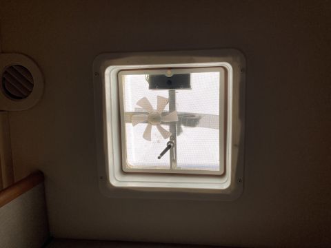 2015 Ford F-550 - Interior view of a roof vent fan with a screen and manual crank mechanism.