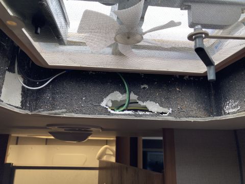 2015 Ford F-550 - A damaged RV ceiling vent with exposed wiring and insulation. The interior of the RV is visible below the damaged vent.