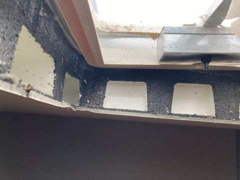2015 Ford F-550 - Close-up view of the edge of a roof vent installation, showing sealant and insulation around the opening.