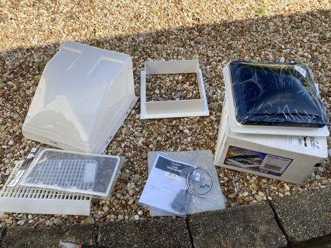 2015 Ford F-550 - A collection of RV vent parts and a box for a Fantastic Fan Model 1200 are laid out on a gravel surface.