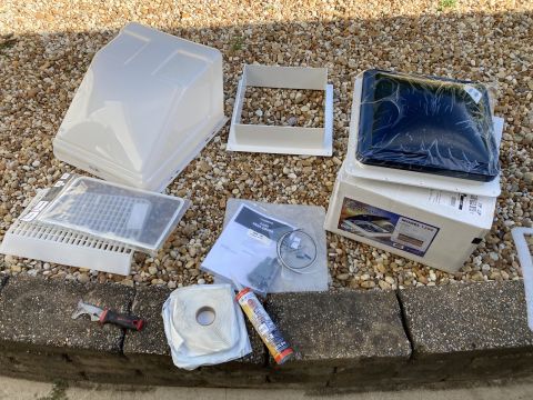 2015 Ford F-550 - A collection of RV roof vent parts and installation supplies are laid out on a gravel surface next to a concrete curb. Visible items includ…