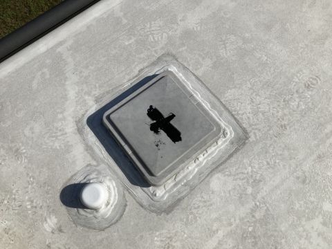 2015 Ford F-550 - A close-up view of a recreational vehicle roof shows a vent cover with black sealant applied around its base, and a white pipe fitting with…