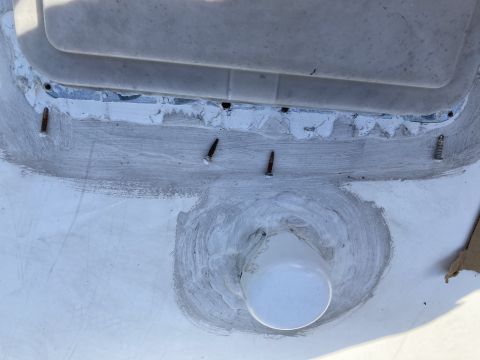 2015 Ford F-550 - A close-up view of sealant applied around a vent and screws on the roof of a vehicle. The sealant is a light gray color and appears to be f…