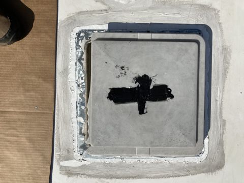 2015 Ford F-550 - A close-up view shows a square vent on a white surface, possibly a roof, with black sealant applied in a cross shape over the vent. The ven…
