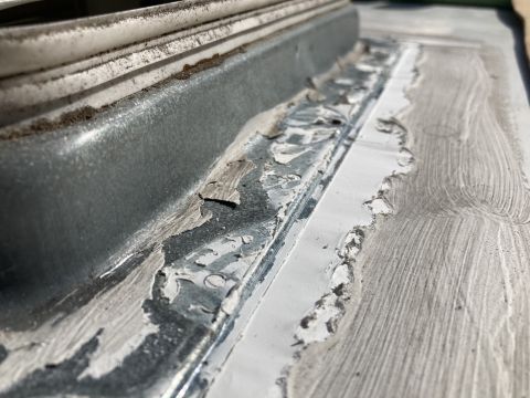 2015 Ford F-550 - A close-up view shows peeling sealant and weathered metal along a seam, likely on a vehicle roof or exterior.