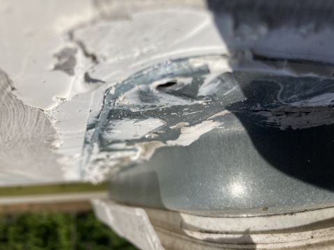 2015 Ford F-550 - A close-up view shows a metal pipe or conduit protruding from a white surface, with gray sealant applied around it. The metal appears to be…