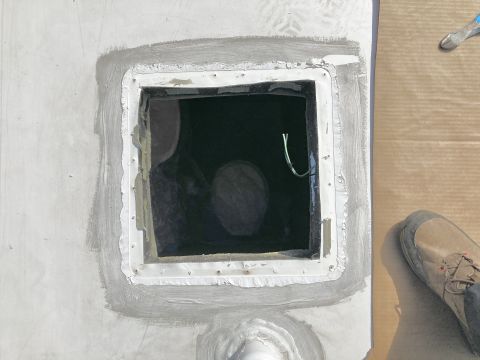 2015 Ford F-550 - A square opening in a white surface is sealed with grey caulk and white tape. A green wire protrudes from the opening.