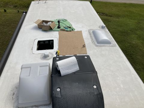 2015 Ford F-550 - The roof of an RV is shown with various components including a vent, a skylight, and what appears to be an air conditioner unit. Tools and…