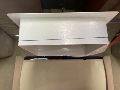 2015 Ford F-550 - A white, rectangular air vent is installed in the ceiling of a vehicle. The vent has a flange that is screwed into the ceiling, and a duct…