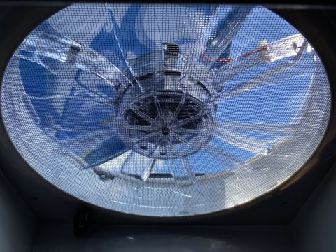 2015 Ford F-550 - View looking up through a RV roof vent fan with a screen cover. The fan blades and motor are visible, along with a bright blue sky and some…