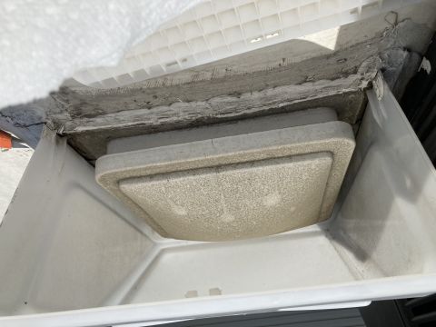 2015 Ford F-550 - A close-up view of a white plastic RV roof vent cover and its housing, showing some wear and sealant around the edges.