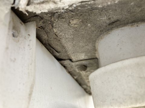 2015 Ford F-550 - A close-up view shows a cracked concrete surface above a white plastic component, possibly part of a vehicle's undercarriage or chassis.