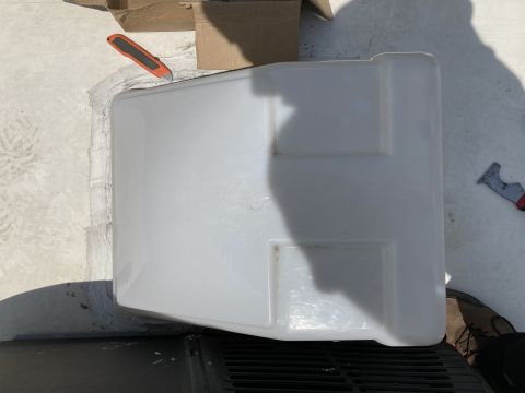 2015 Ford F-550 - A white plastic cover is placed over a black vent on a flat surface, with a utility knife and a scraper nearby. A cardboard box is visible…