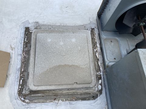 2015 Ford F-550 - A close-up view of a roof vent cover on an RV, showing some wear and tear around the edges and sealant.
