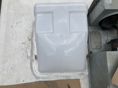 2015 Ford F-550 - A white plastic cover is installed over a roof-mounted HVAC unit on a vehicle. The cover has a slightly rounded top and two rectangular ind…