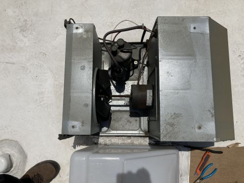 2015 Ford F-550 - Overhead view of an open rooftop air conditioner or vent unit showing motor, fan and sheet-metal housing.