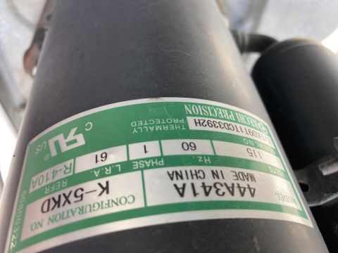 2015 Ford F-550 - Data spec plate on an HVAC compressor listing model, refrigerant R-410A, voltage and configuration.