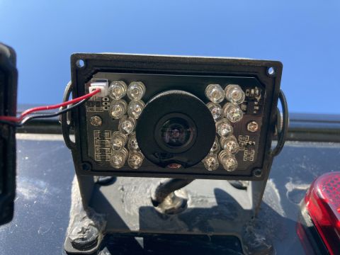 2015 Ford F-550 - A close-up rear view of a backup camera mounted on a dark vehicle, with the blue sky visible in the background.