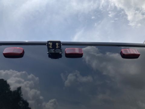 2015 Ford F-550 - A traffic signal hangs above, its red lights illuminated under a dramatic, overcast sky.