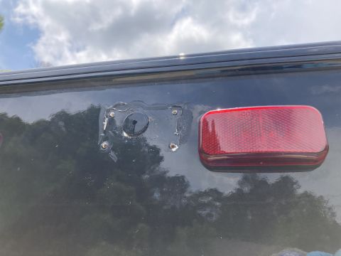2015 Ford F-550 - Rear view of a dark vehicle, missing its license plate bracket and showing a red taillight.