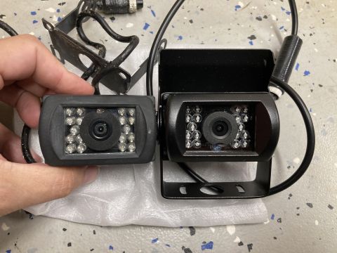 2015 Ford F-550 - Two backup cameras are shown, one held in a hand and the other mounted on a bracket.