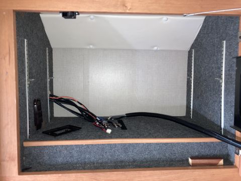 2015 Ford F-550 - This image shows the interior of a cabinet with various cables and wiring. There are also some mounting brackets and a black plastic insert…
