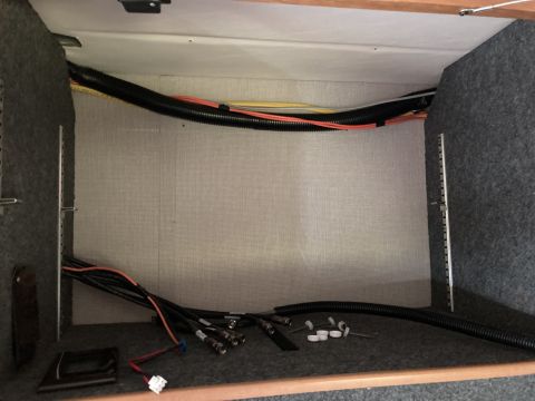 2015 Ford F-550 - A view inside a storage compartment showing various electrical wires and cables, some bundled in black corrugated tubing. The compartment i…
