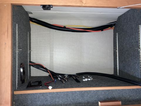 2015 Ford F-550 - A view inside a cabinet or compartment, showing various electrical wires and cables neatly organized and routed through black protective tu…