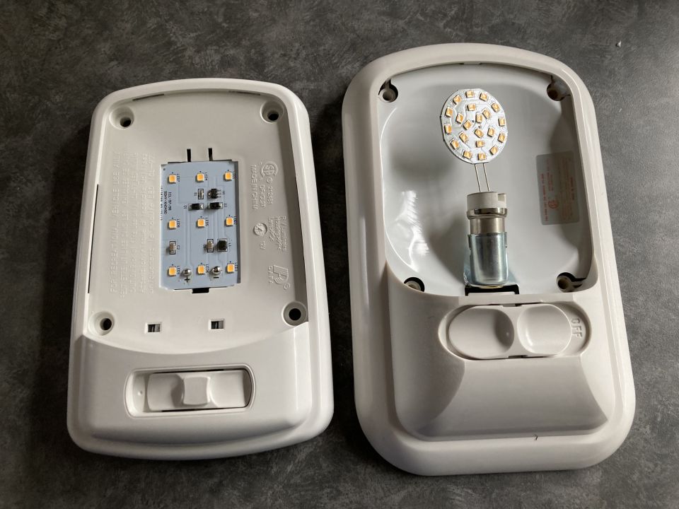 Two white RV interior dome lights, one with a rectangular LED board, the other with a circular LED board.