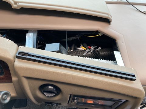 2015 Ford F-550 - Close-up view of the interior dashboard area of a motorhome, showing exposed wiring, ducting, and an aftermarket stereo system.