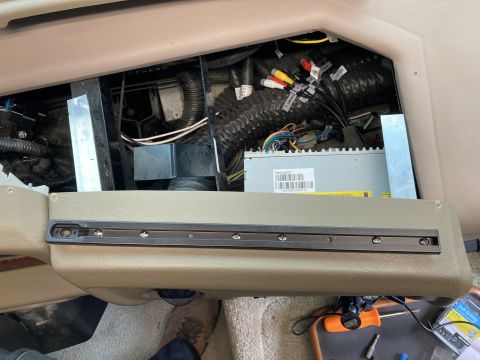 2015 Ford F-550 - A close-up view of the interior of a vehicle, showing a section of the dashboard with wiring and electronic components exposed. A dark meta…