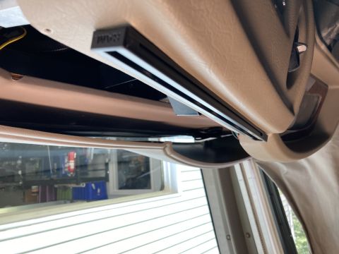 2015 Ford F-550 - A close-up view of a gray RAM-branded mount attached to the tan interior of a vehicle, likely an overhead console.
