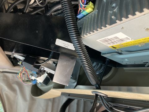 2015 Ford F-550 - A close-up view shows the underside of a vehicle's dashboard, revealing wiring harnesses, a black metal bracket, and a car stereo with a wa…