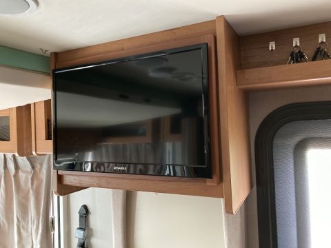 2015 Ford F-550 - A flat-screen television is mounted under a wooden cabinet in an RV.